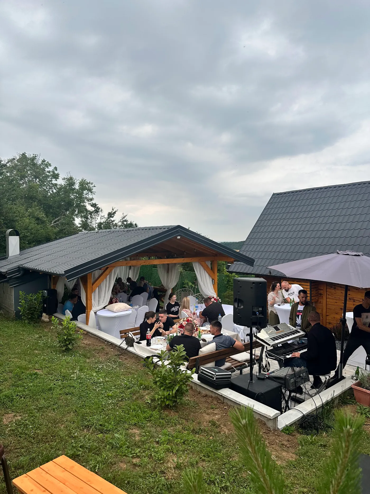 gathering under a wooden canopy in a backyard - Banstol - frame 2